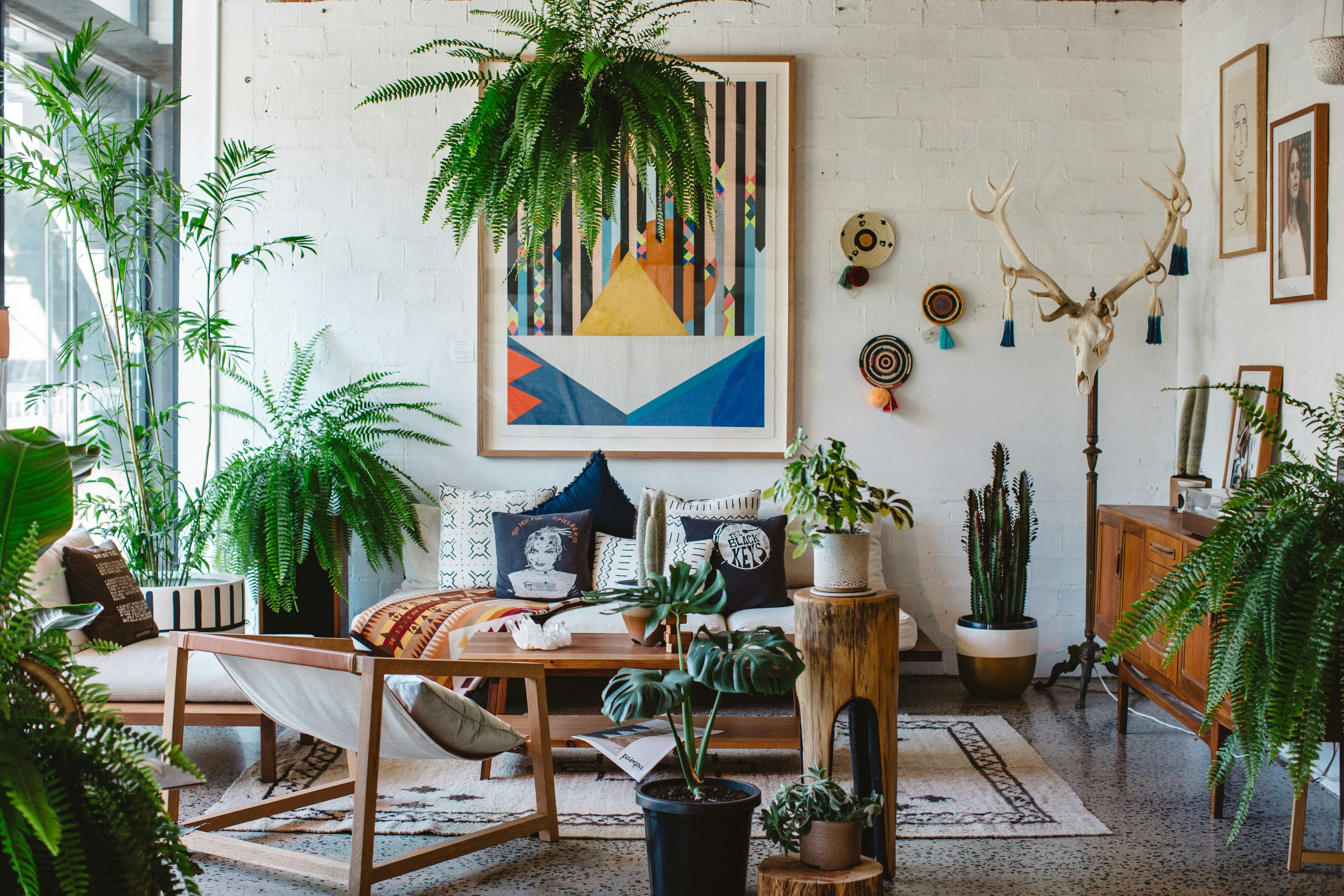 tiered plant stand on apartment balcony with green plants